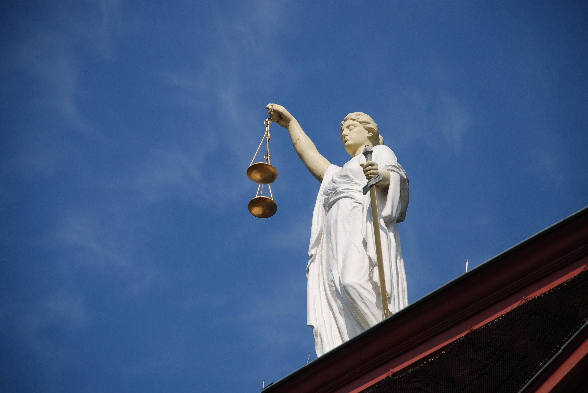 Justizia auf einem Dach, von unten fotografiert vor blauem Himmel. Rechtskonform laut EuGH: Gebrauchte Software.